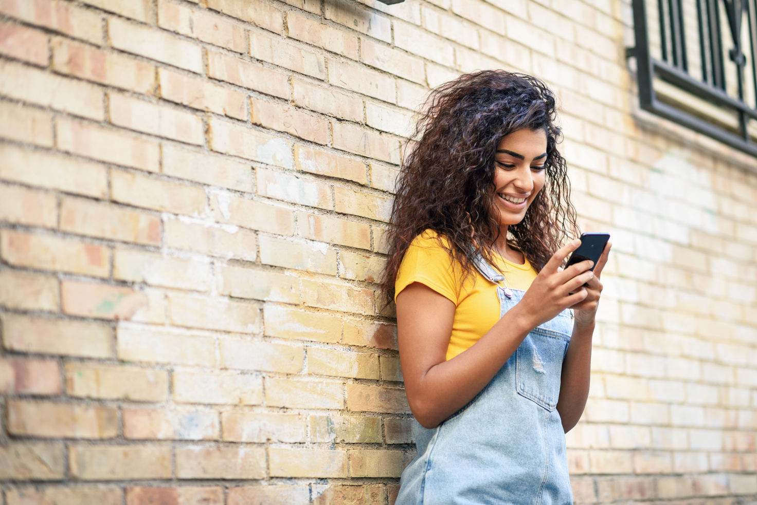 Young North African Woman Texting with Her Smart Phone Outdoors